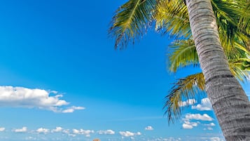 On the beach, white sand, sun loungers, beach towels