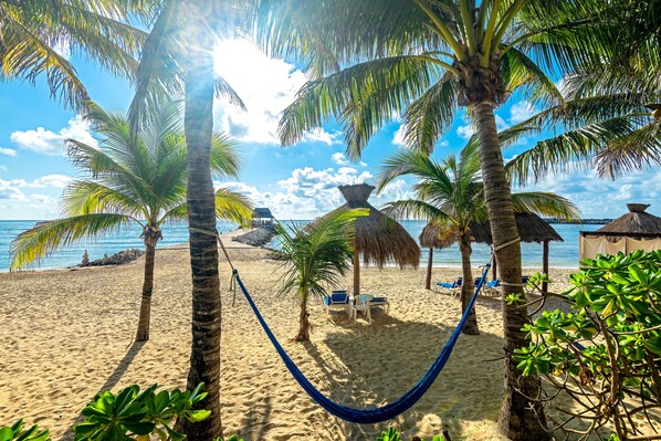 On the beach, white sand, sun loungers, beach towels