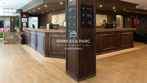 A reception desk with a sign indicating amenities like a restaurant, spa, and piano bar.