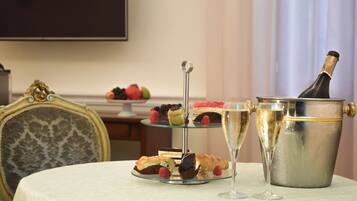A table with a dessert display, champagne glasses, and a champagne bottle.