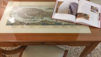 Un libro abierto mostrando un mapa de Venecia y otra página con texto e imágenes.