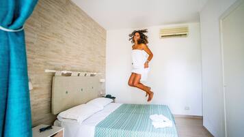 Una camera da letto con un letto, un comodino e un condizionatore d'aria a parete.
