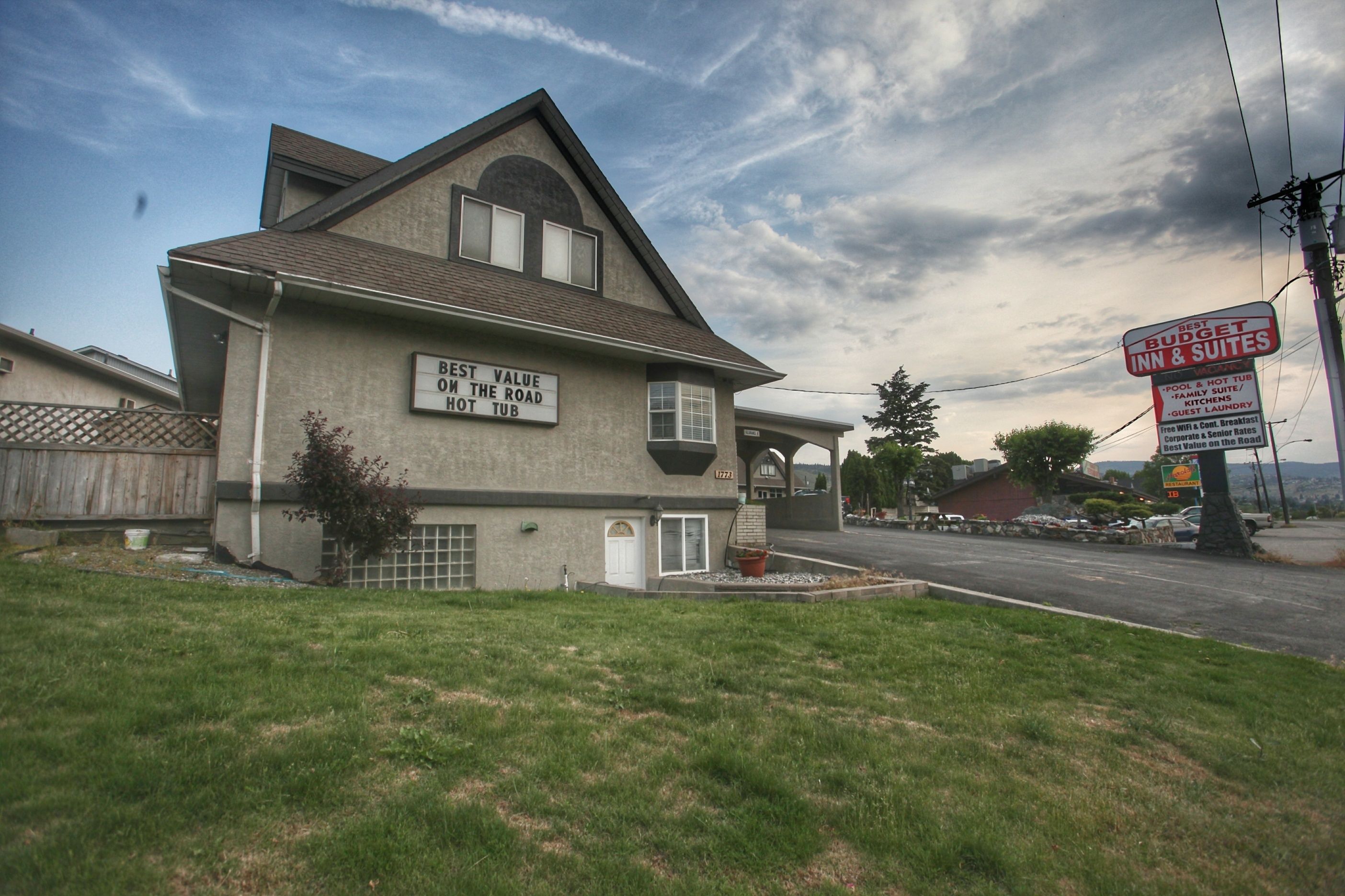A two-story building with a sign stating "Best Value on the Road Hot Tub."
