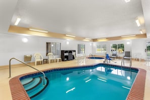 A swimming pool with a tiled edge, a sunken seating area, and a sunroof.