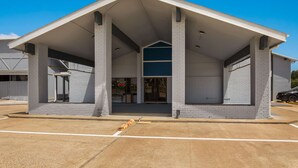 A building with a flat roof, large columns, and a clear entrance. - Quality Inn Madisonville (Madisonville)