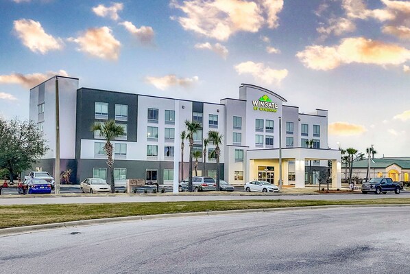 A modern hotel with a flat roof, multiple windows, and a sign reading "Wingate by Wyndham".