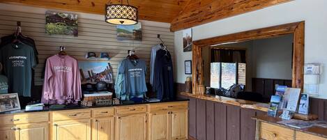 A wooden interior with a wooden ceiling, a hanging light fixture, and a counter displaying various items.