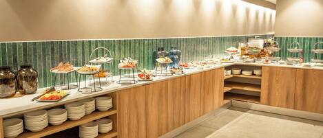 A buffet setup with various food items and serving ware.
