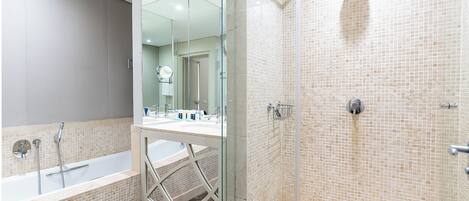 A modern bathroom with a glass-enclosed shower, a bathtub, and a vanity with a mirror.