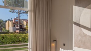 Habitación de hotel moderna con una cama grande, vistas al exterior y una decoración minimalista.