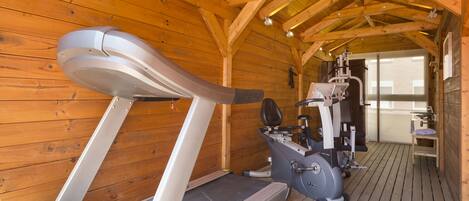 A wooden cabin with a treadmill and exercise equipment.