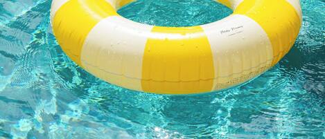A yellow and white inflatable ring in a clear blue pool.