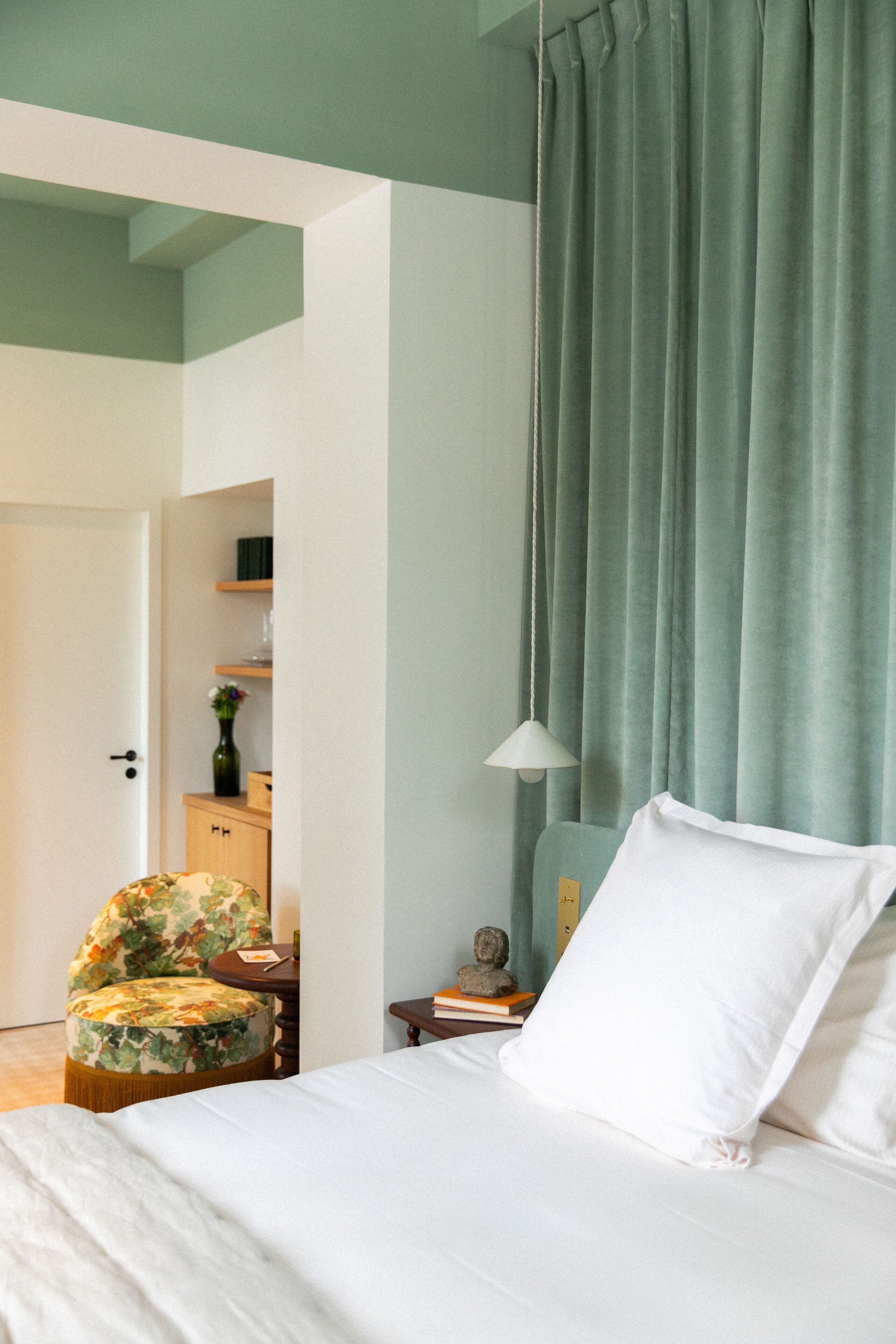Une chambre bien rangée, avec un lit, une chaise, une petite table et une lampe.