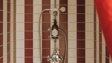 Une salle de bain avec un mur carrelé, une pomme de douche et un pommeau de douche amovible.