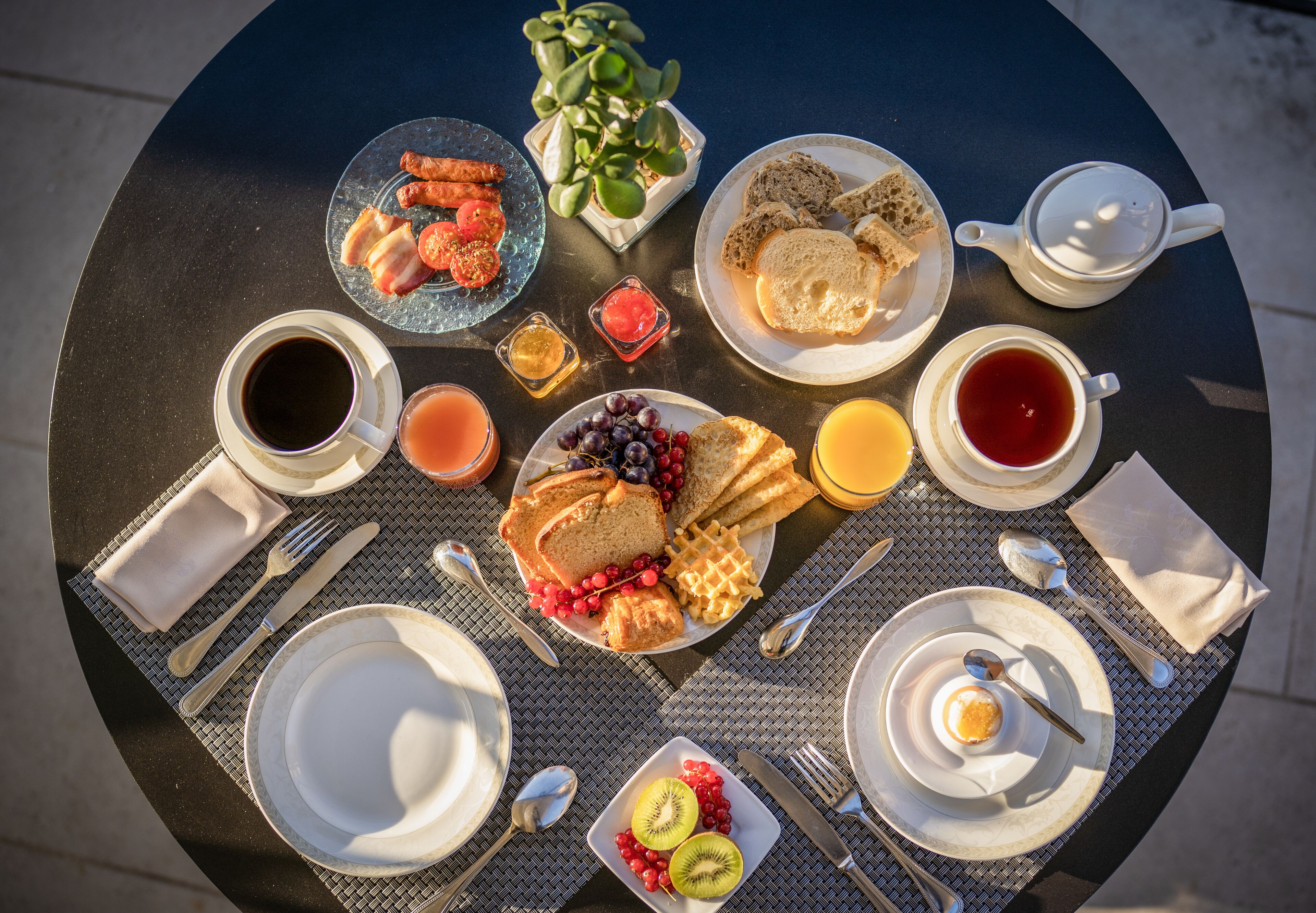A round table with breakfast items including toast, eggs, and fruit.