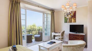 Une chambre d’hôtel équipée d’un lit, d’un bureau, d’une chaise, d’une télévision et d’un balcon avec vue.