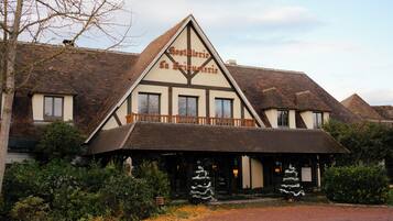 A traditional building with a prominent triangular gable, a balcony, and a sign reading "Gostellerie La Brindesierie".