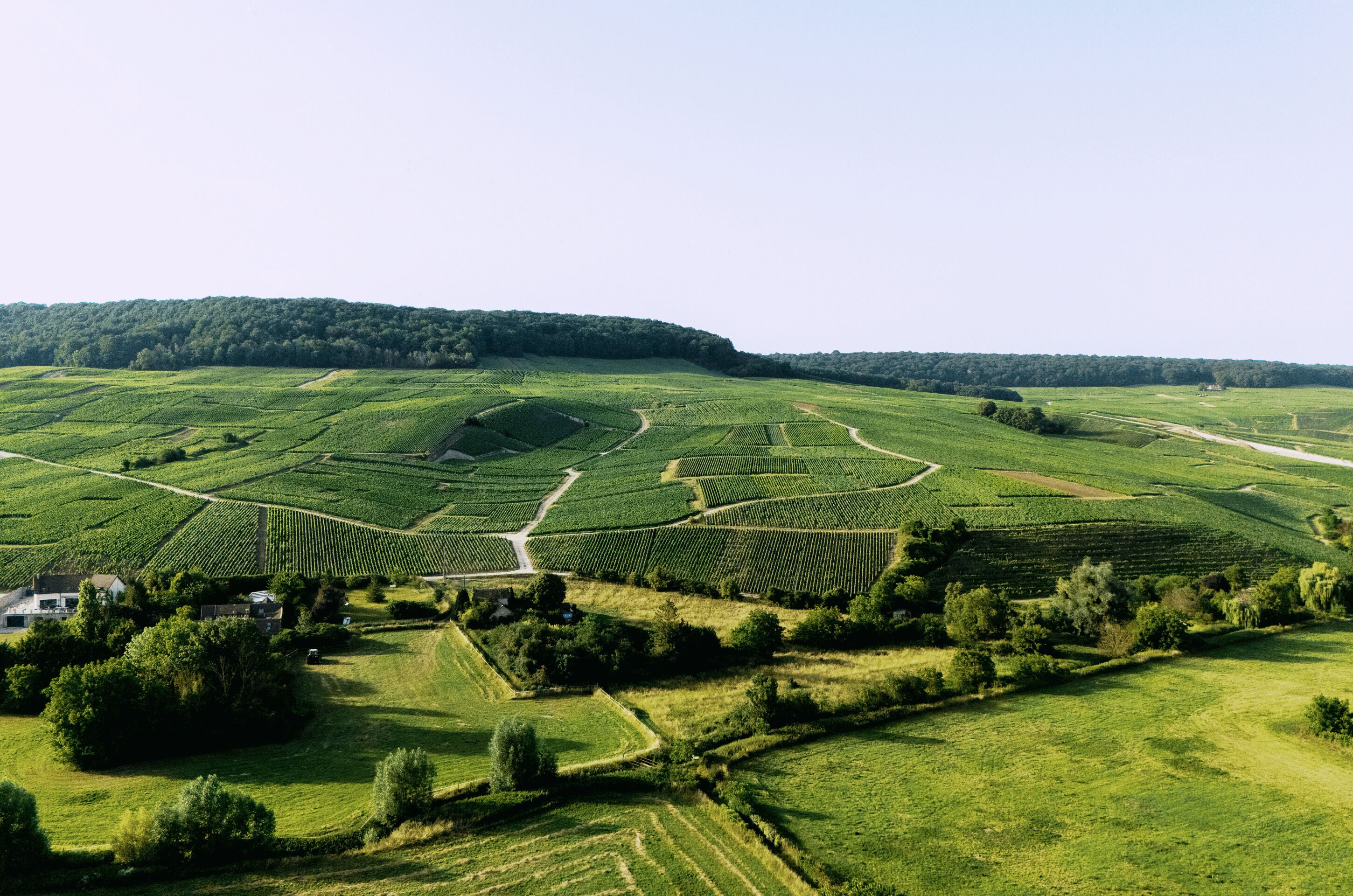 Een landelijk landschap met terrassen en enkele gebouwen.