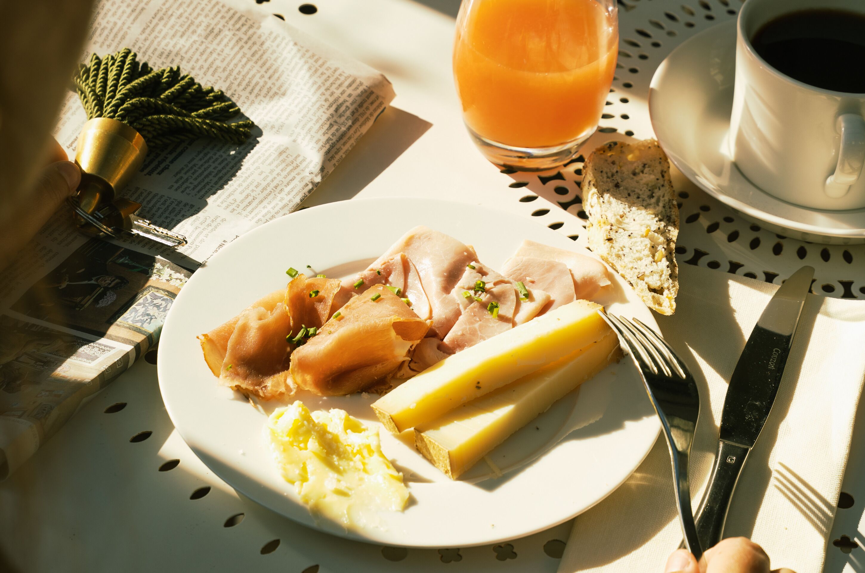 A breakfast setting with a plate of food, a glass of orange juice, and a cup of coffee on a table.
