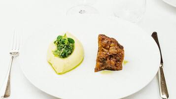 A plate with a piece of meat and a green vegetable dish.