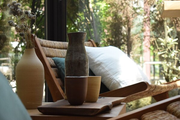 Una mesa de madera con un florero, una taza y un cuenco encima.