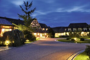 Un hotel de estilo arquitectónico europeo tradicional, con un característico techo triangular y una entrada bien iluminada.