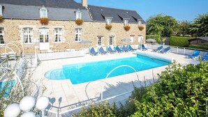 A stone building with a swimming pool, lounge chairs, and a clear blue sky. - La Malouinière Des Longchamps (Saint-Jouan-des-Guerets)