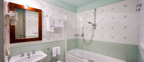 A bathroom with a sink, bidet, and bathtub.