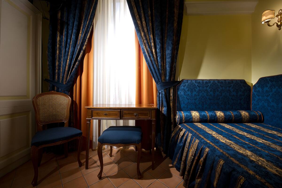 A room with a bed, a desk, and a chair.