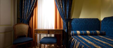 A room with a bed, a desk, and a chair.