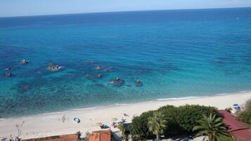 Plage privée, sable blanc, chaises longues, parasols
