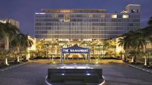 Een modern hotel met een opvallende ingang, met daarop de tekst 'The Kilimanjaro'.