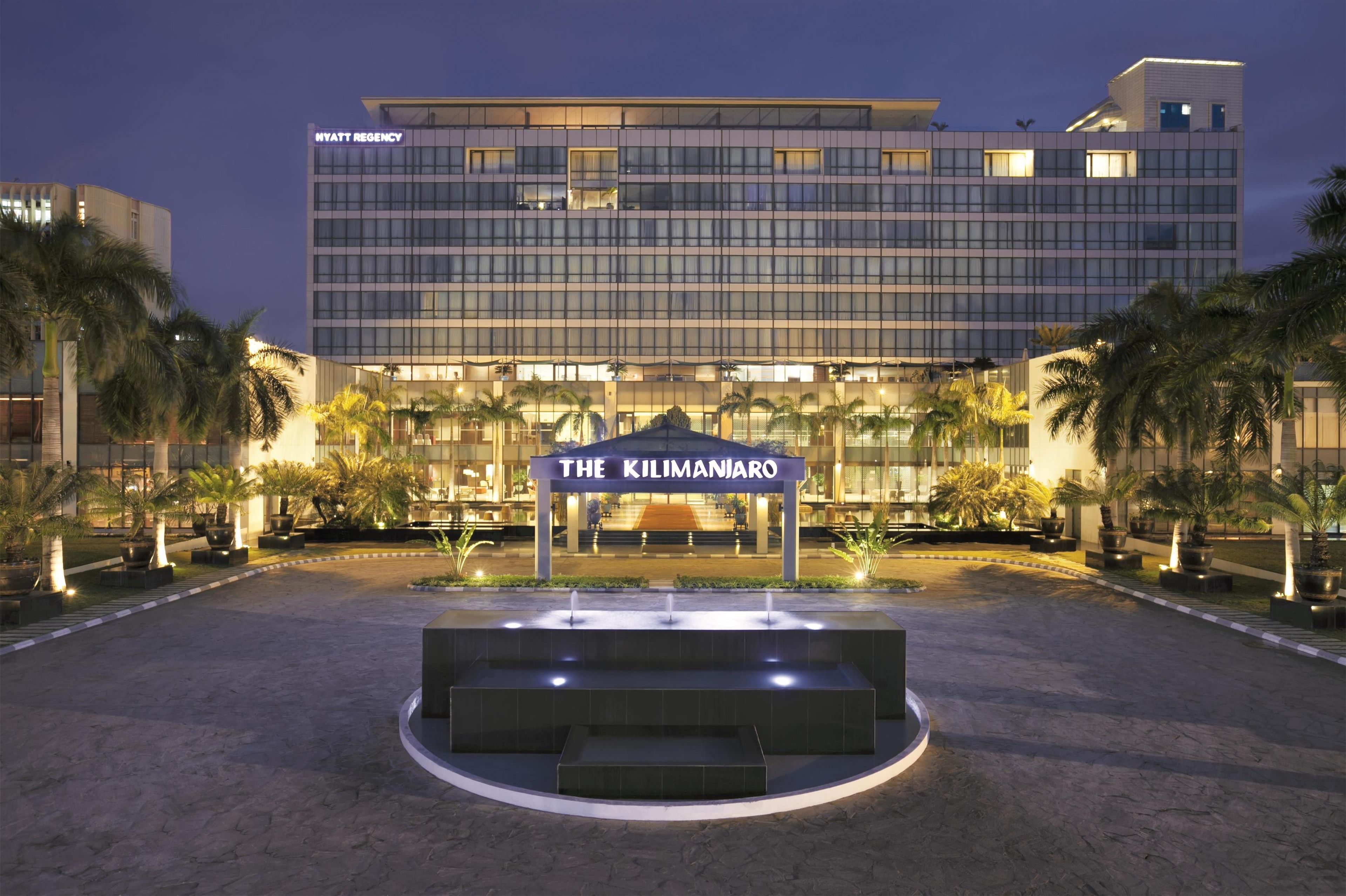 Um hotel moderno com uma entrada imponente identificada como 'The Kilimanjaro'.