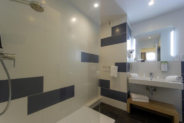 A modern bathroom with a shower, a sink, and a mirror. - Kyriad Montpellier Est - Lunel (Lunel)