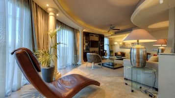 Una sala de estar moderna con un sillón de cuero, una mesa de centro de vidrio y una lámpara de pie grande.