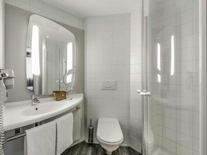 A modern bathroom with a sink, mirror, toilet, and shower. - ibis Innsbruck (Innsbruck)
