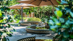 Een patio met tuinmeubilair en een fontein in het midden.