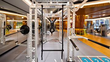 A gym with a pull-up bar, weight racks, and exercise equipment.