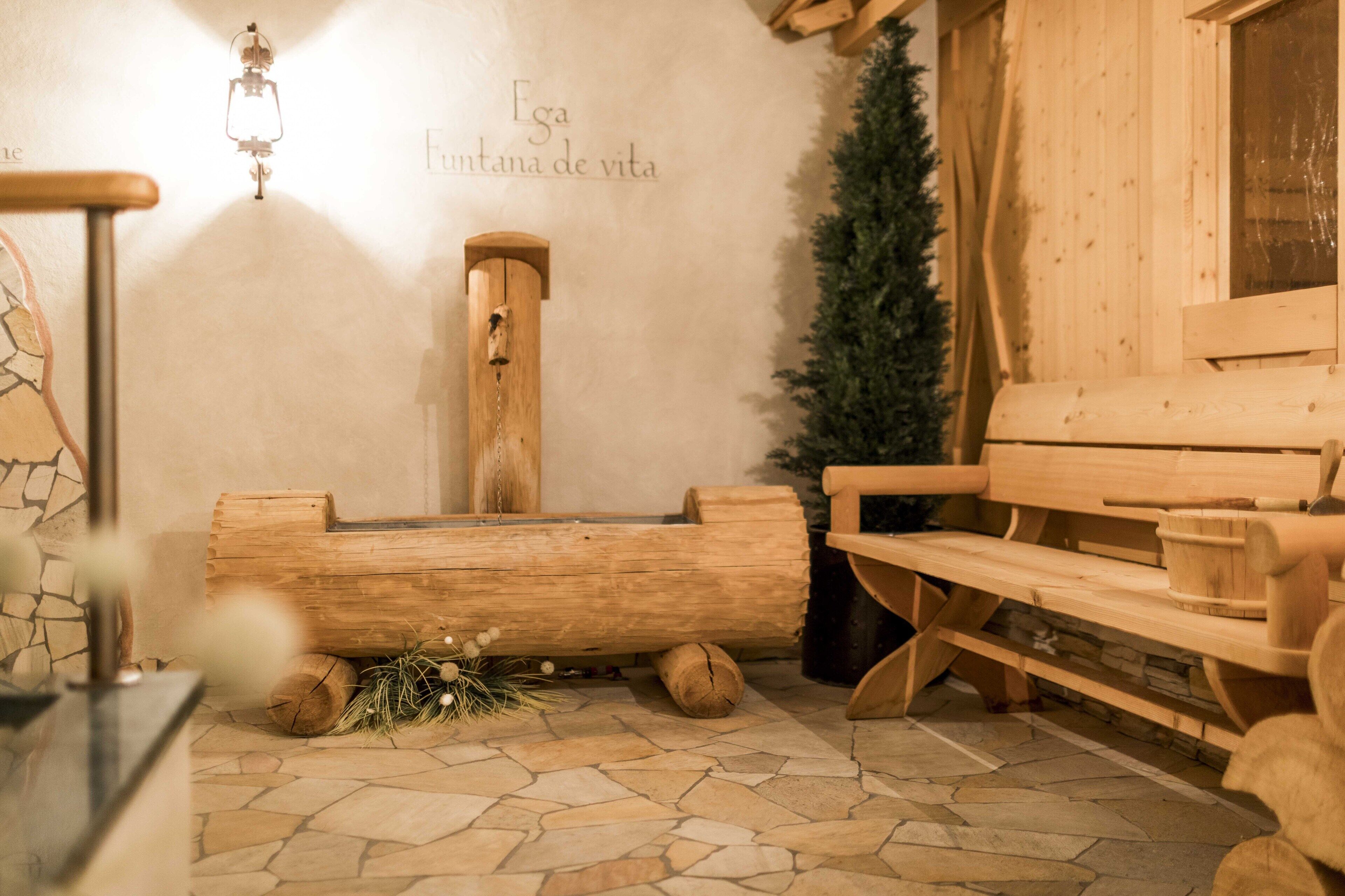 Un sauna en bois avec des bancs et un banc en bois muni d’un seau.