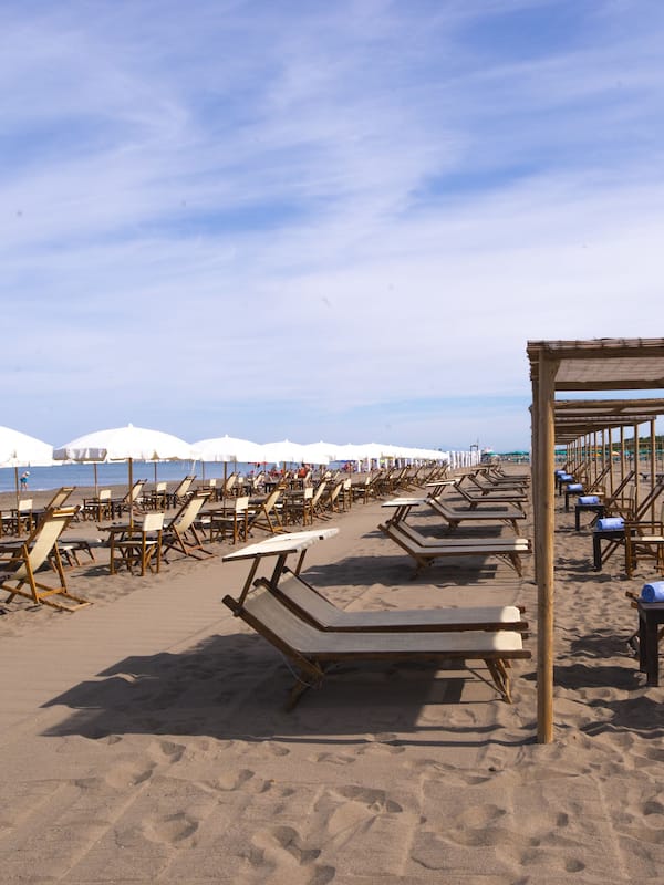 Relax on the beach with comfortable sun loungers and umbrellas under a shaded canopy.