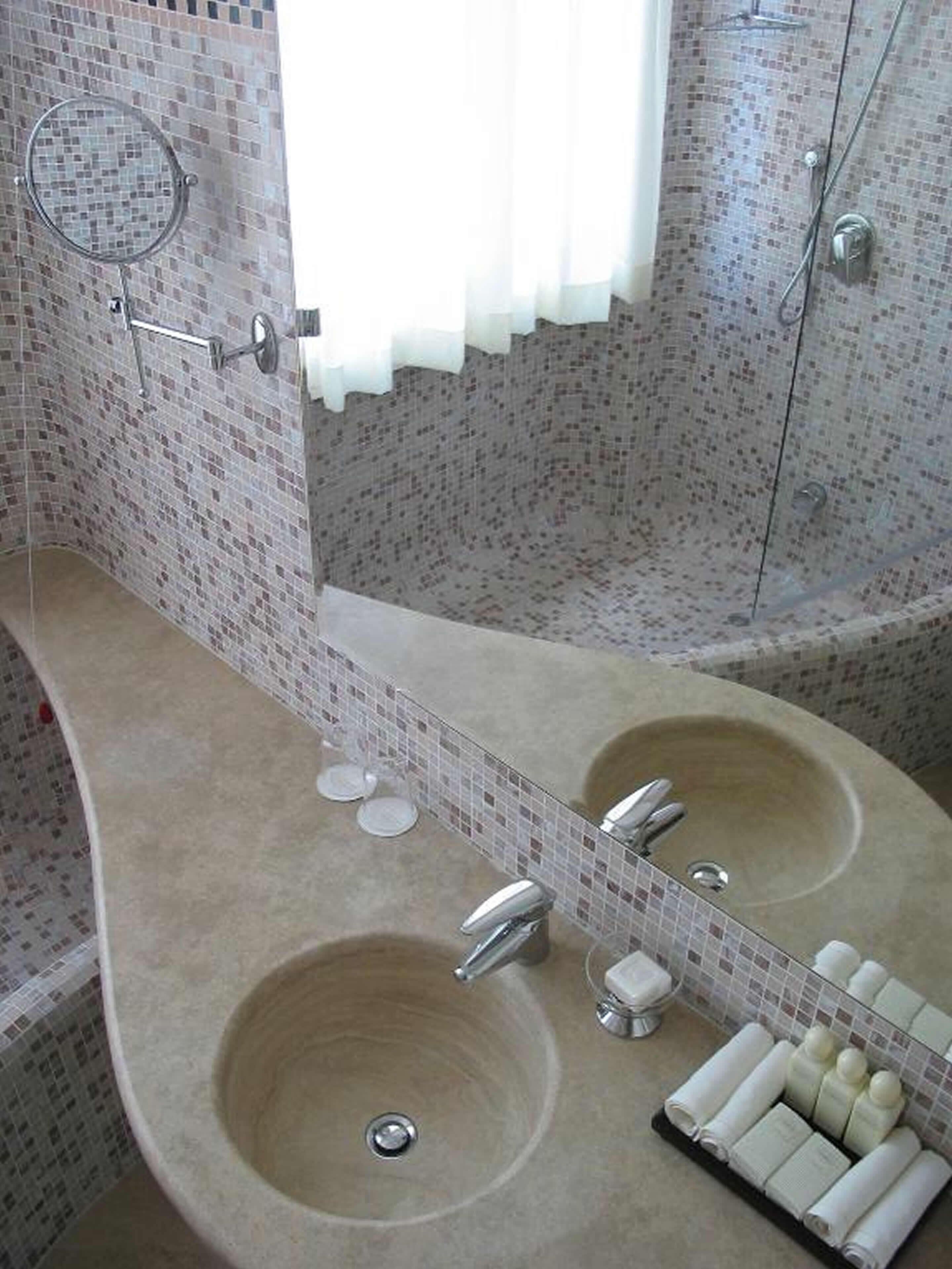 A bathroom with two sinks, a shower, and a mirror.