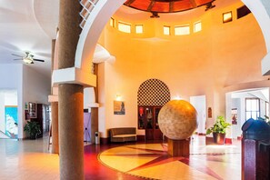 A spacious lobby with a high ceiling, a central seating area, and a large decorative sphere.