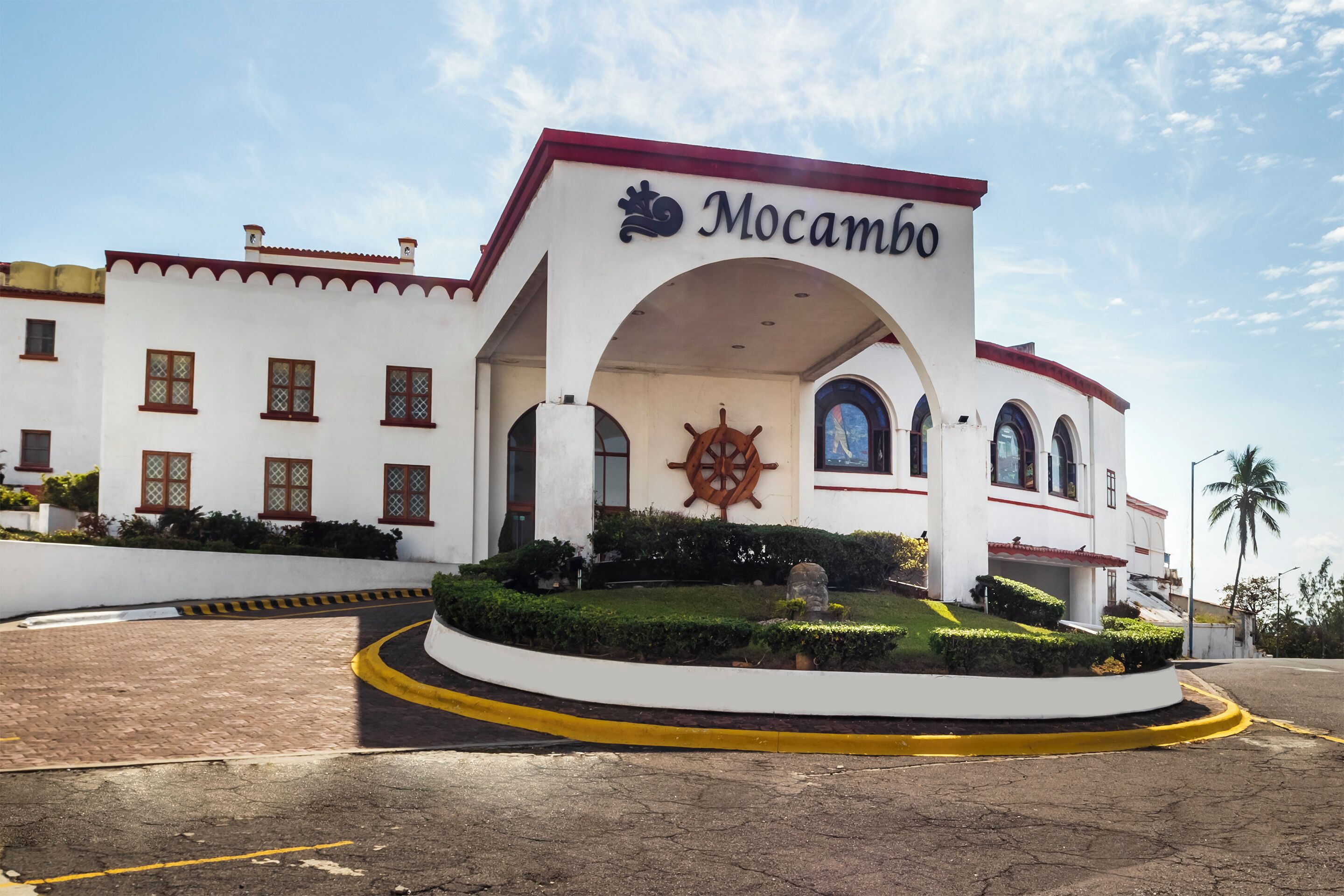 Un bâtiment blanc avec un toit rouge et une enseigne sur laquelle on peut lire « Mocambo ».