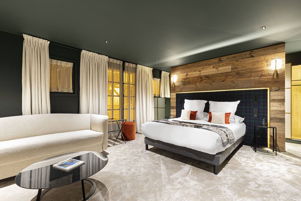 Um quarto moderno com uma cama grande, um sofá e uma mesa de centro.