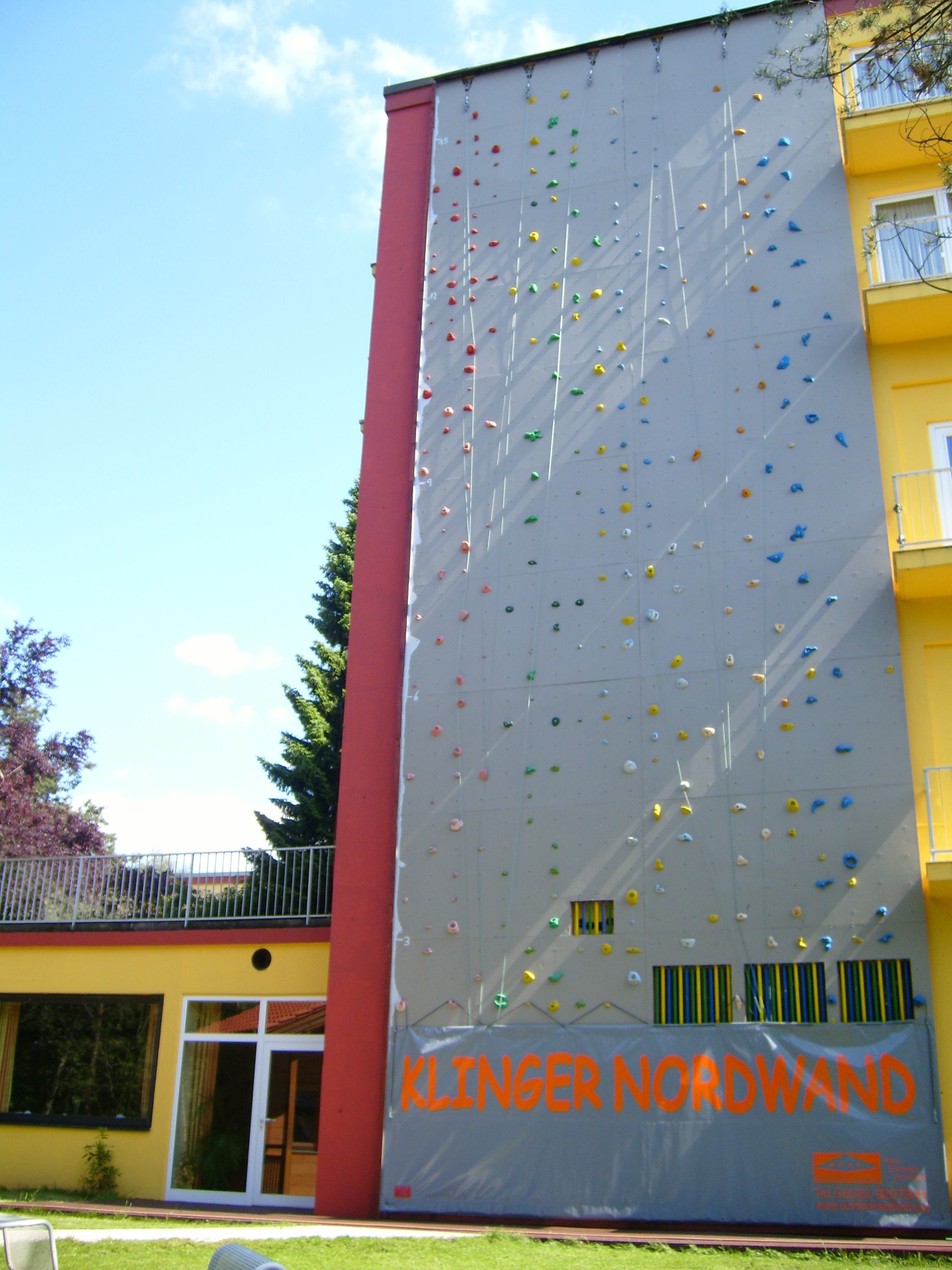 Uma parede de escalada com o texto "KLINGER NORDWAND" na fachada de um edifício.