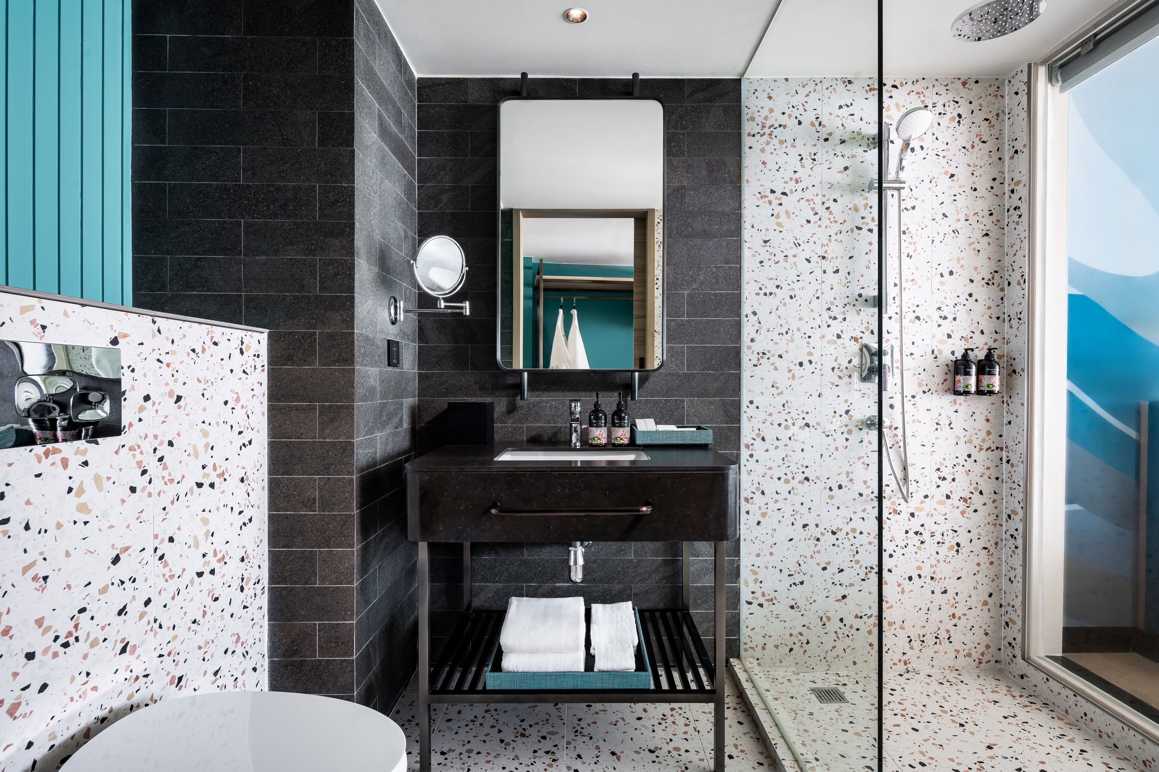 A modern bathroom with a freestanding bathtub, a glass-enclosed shower, and a vanity with a mirror and sink.