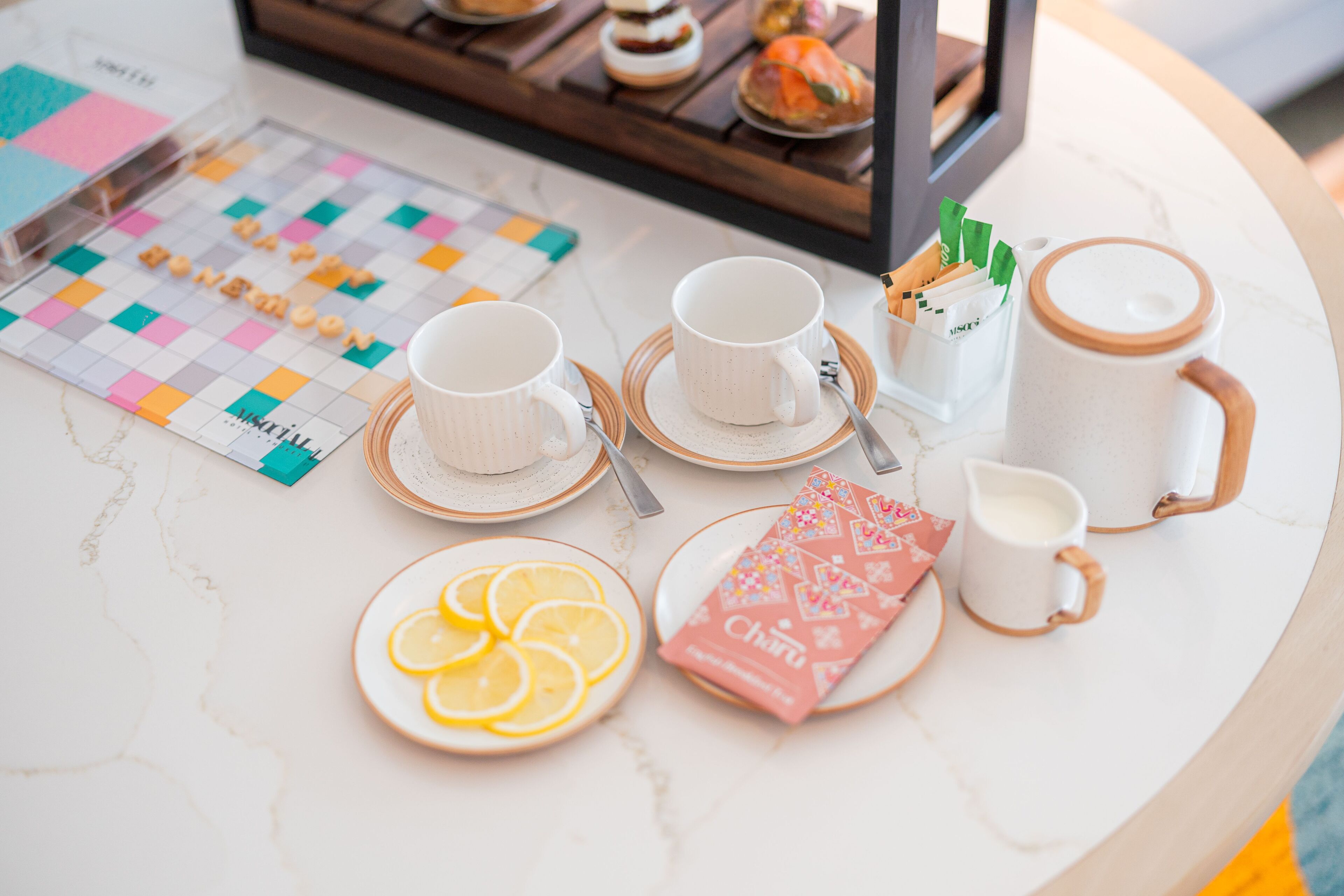 Una mesa de desayuno con tazas, platos y una bandeja de comida.
