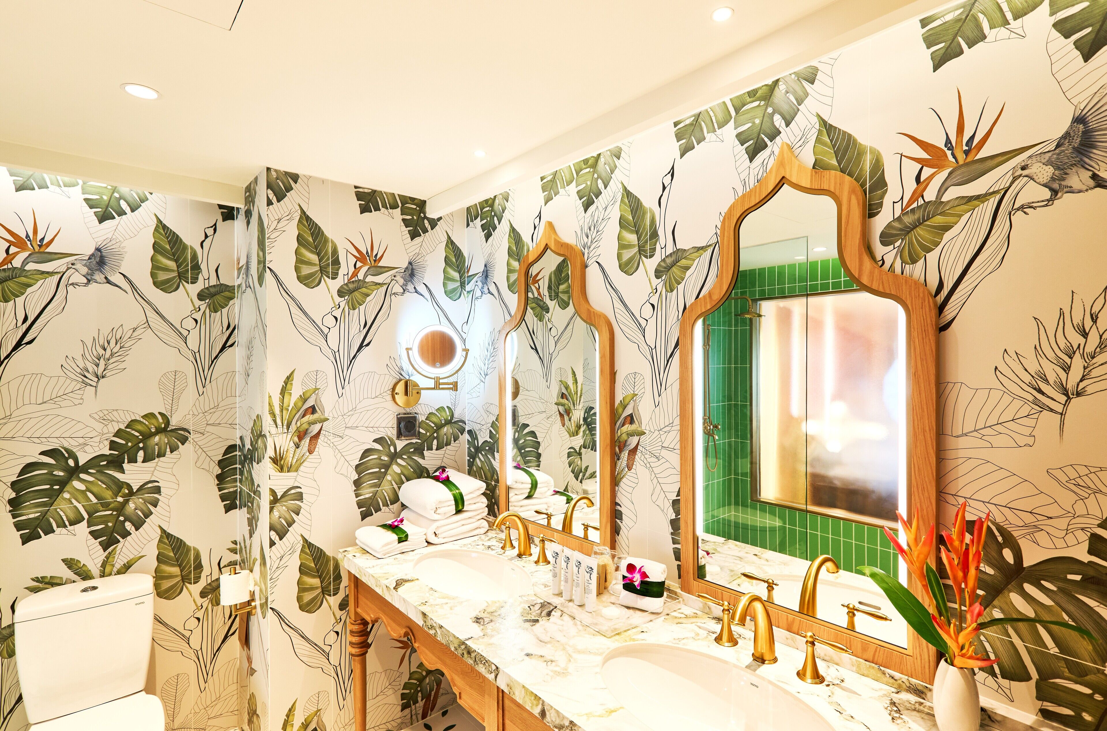A bathroom with a vanity, two mirrors, a sink, and a toilet.