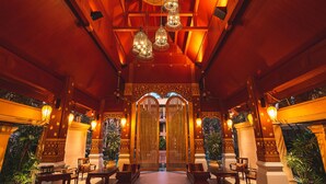 An indoor space with a wooden ceiling, multiple hanging lights, and a central entrance with decorative doors. - Burasari Phuket Resort & Spa (Patong)