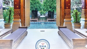 A luxurious hotel entrance with a pool view, ornate arches, and potted plants. - Burasari Phuket Resort & Spa (Patong)